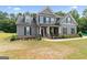 Two-story home featuring gray siding, a covered front porch, and a neatly maintained lawn at 935 S Laney Rd, Locust Grove, GA 30248