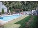 Backyard pool featuring stone border, covered outdoor seating area and expansive lawn in a fenced yard at 401 N Lost Lake Cv, Villa Rica, GA 30180