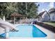 Relaxing backyard pool with stone surround, a slide, and a pergola-covered seating area at 401 N Lost Lake Cv, Villa Rica, GA 30180