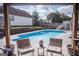 Relaxing poolside seating with a charming view of the pool and surrounding landscape at 401 N Lost Lake Cv, Villa Rica, GA 30180