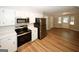 Modern kitchen with stainless steel appliances, white cabinetry, and wood-look flooring, perfect for cooking and entertaining guests at 500 Carillon Ct, Stone Mountain, GA 30083