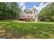Large backyard with a well-maintained lawn, complemented by a multi-level wooden deck offering serene outdoor living at 145 Driftwood Trl, Fayetteville, GA 30215