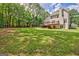 Expansive backyard featuring lush green grass, mature trees, and a spacious deck perfect for outdoor entertaining at 145 Driftwood Trl, Fayetteville, GA 30215