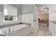 Bright bathroom featuring a large soaking tub and views into the main bedroom at 145 Driftwood Trl, Fayetteville, GA 30215