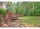 Cozy outdoor deck with steps leading to a landscaped patio featuring stone pavers and beautiful green surroundings at 145 Driftwood Trl, Fayetteville, GA 30215