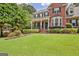 Well-maintained two-story brick home boasting a manicured lawn, covered porch, and mature landscaping at 145 Driftwood Trl, Fayetteville, GA 30215