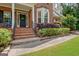 Brick steps lead to the front door, framed by a bay window and manicured shrubbery at 145 Driftwood Trl, Fayetteville, GA 30215