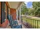 Inviting front porch with rocking chairs, brick pillars, and a view of the neighborhood street at 145 Driftwood Trl, Fayetteville, GA 30215