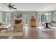 Open-concept living room featuring a brick fireplace, wood floors, and abundant natural light at 145 Driftwood Trl, Fayetteville, GA 30215