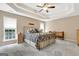 Bright main bedroom features a ceiling fan, tray ceiling and lots of natural light at 145 Driftwood Trl, Fayetteville, GA 30215