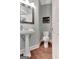 Cozy powder room features a pedestal sink, hardwood floors, and modern fixtures for added convenience at 145 Driftwood Trl, Fayetteville, GA 30215
