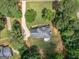 An aerial perspective showcases a home nestled amongst trees, featuring a well-manicured lawn and private backyard at 416 River Forest Dr, Mcdonough, GA 30252