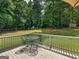 View of a wooden deck with a metal table and chairs, overlooking the green backyard at 416 River Forest Dr, Mcdonough, GA 30252