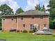 Exterior view of a brick home with a deck overlooking the grassy backyard, shaded by trees at 416 River Forest Dr, Mcdonough, GA 30252