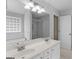 Bright bathroom boasts a double sink vanity, glass block window, and a walk-in shower, offering style and convenience at 416 River Forest Dr, Mcdonough, GA 30252