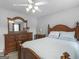Bright bedroom with wooden furniture set, ceiling fan, and neutral walls at 416 River Forest Dr, Mcdonough, GA 30252