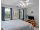 Cozy bedroom features bright windows, a ceiling fan, and a wooden bed frame at 416 River Forest Dr, Mcdonough, GA 30252