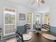 Dining room features a round wood table, chair rail, and dual windows for natural light at 416 River Forest Dr, Mcdonough, GA 30252