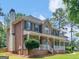 Exterior view of a red brick home with a covered porch, green shutters, and a well-manicured front yard at 416 River Forest Dr, Mcdonough, GA 30252
