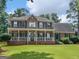 Exterior front view of a red brick house with a charming porch, surrounded by a green lawn at 416 River Forest Dr, Mcdonough, GA 30252