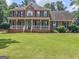 Charming brick home featuring a classic white porch, green shutters, and a well-maintained lawn at 416 River Forest Dr, Mcdonough, GA 30252