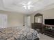 View of a large bedroom featuring a tray ceiling and dark furniture, seamlessly connects to the en-suite bathroom at 416 River Forest Dr, Mcdonough, GA 30252