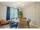 Inviting dining room featuring a round wood table, stylish lighting, and large windows with blue curtains at 3833 Bakers Ferry Sw Rd, Atlanta, GA 30331