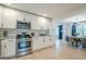 Well-lit open kitchen with stainless steel appliances, granite countertops, and seamless transition to the dining area at 3833 Bakers Ferry Sw Rd, Atlanta, GA 30331