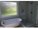 Elegant bathroom featuring a freestanding tub, a separate glass-enclosed shower, and stylish tile work at 216 Lake Tanisha Dr, Dallas, GA 30157