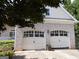 Spacious two-car garage with white doors matching the home's exterior, offering ample parking and storage space at 216 Lake Tanisha Dr, Dallas, GA 30157