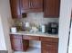 Convenient coffee bar area with dark wood cabinets, granite countertops, and space for coffee machines and accessories at 216 Lake Tanisha Dr, Dallas, GA 30157
