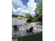 Scenic lake view with a sandy beach area featuring Adirondack chairs and a covered boat dock at 216 Lake Tanisha Dr, Dallas, GA 30157