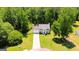 Aerial view of the house with a long driveway and a manicured lawn surrounded by lush trees at 420 Callaway Pt, Mcdonough, GA 30252