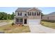 Charming two-story home featuring brick and gray siding, black shutters, manicured lawn, and an attached two-car garage at 612 Whitman Ln, Stockbridge, GA 30281