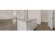 Spacious kitchen island with granite top and white cabinetry opens to a living area with hardwood floors at 612 Whitman Ln, Stockbridge, GA 30281