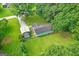 Aerial view of a green home, shed, and green surroundings showcasing the property's location at 107 Club Dr, Locust Grove, GA 30248