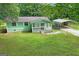 Aerial view of a quaint home with a large yard and a convenient carport at 107 Club Dr, Locust Grove, GA 30248
