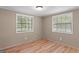 Bright bedroom with two windows, wood-look flooring, and neutral colored walls at 107 Club Dr, Locust Grove, GA 30248