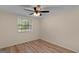Inviting bedroom with wood-look floors, a ceiling fan, and a window offering natural light at 107 Club Dr, Locust Grove, GA 30248