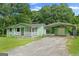 Charming green home with covered parking, a shed, and a well-maintained lawn at 107 Club Dr, Locust Grove, GA 30248