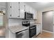 Modern kitchen featuring stainless steel appliances, granite countertops, and white cabinets at 107 Club Dr, Locust Grove, GA 30248
