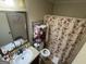 Small bathroom with a white toilet and pink floral curtain at 2663 Shiloh Hills Ct, Snellville, GA 30039