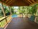 Charming covered back porch with wood floors offering a view of the refreshing backyard pool at 5445 Maltdie, Sugar Hill, GA 30518