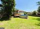 Lush backyard featuring a well-maintained lawn, a wooden deck attached to the house, and an above-ground pool at 5445 Maltdie, Sugar Hill, GA 30518