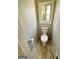 A cozy powder room features a white toilet, a small window, and neutral tile flooring at 5445 Maltdie, Sugar Hill, GA 30518