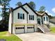 Side view of the house showing the 2-car garage, siding, dark shutters, and well-maintained yard at 5445 Maltdie, Sugar Hill, GA 30518