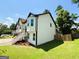 Side view of the home highlighting the yard, entrance staircase, attached garage, and beautiful landscaping at 5445 Maltdie, Sugar Hill, GA 30518