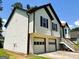 Side view of the house showing the 2-car garage, siding, dark shutters, and well-maintained yard at 5445 Maltdie, Sugar Hill, GA 30518