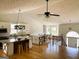 Open-concept kitchen and dining area features hardwood floors, granite countertops, a large island, and a vaulted ceiling at 5445 Maltdie, Sugar Hill, GA 30518