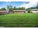Spacious backyard featuring lush green grass and a brick house in the distance under a blue sky at 6233 Castlewood Dr, Morrow, GA 30260